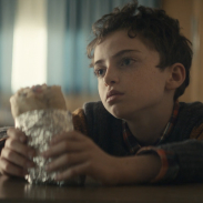 Pensive kid holding a burrito.